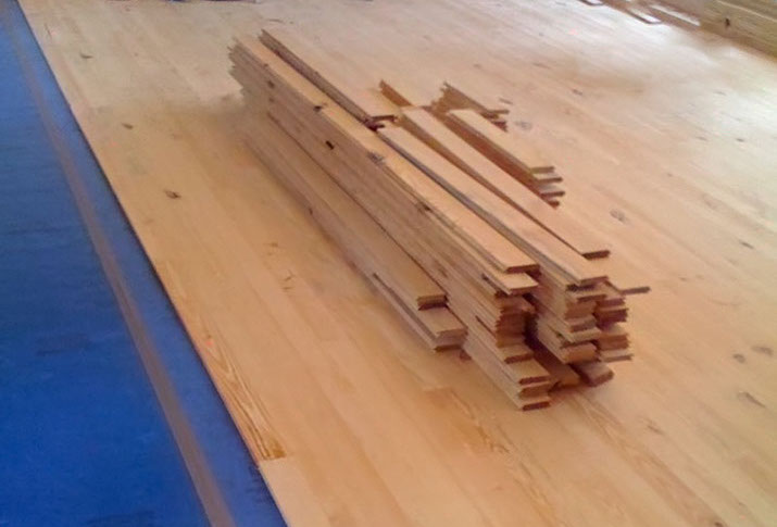 Timber cut and dried from yard being placed as a heart pine floor in Timber Frame Great Room.